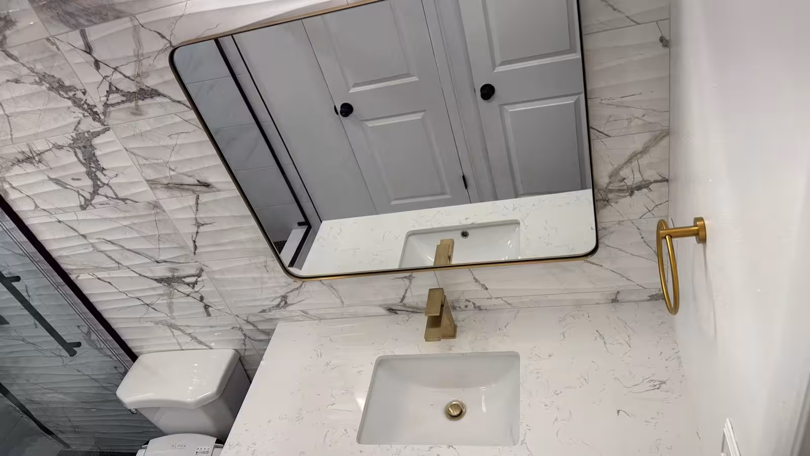 Gold faucet vanity top and accent wall tile close-up in Aurora bathroom remodel