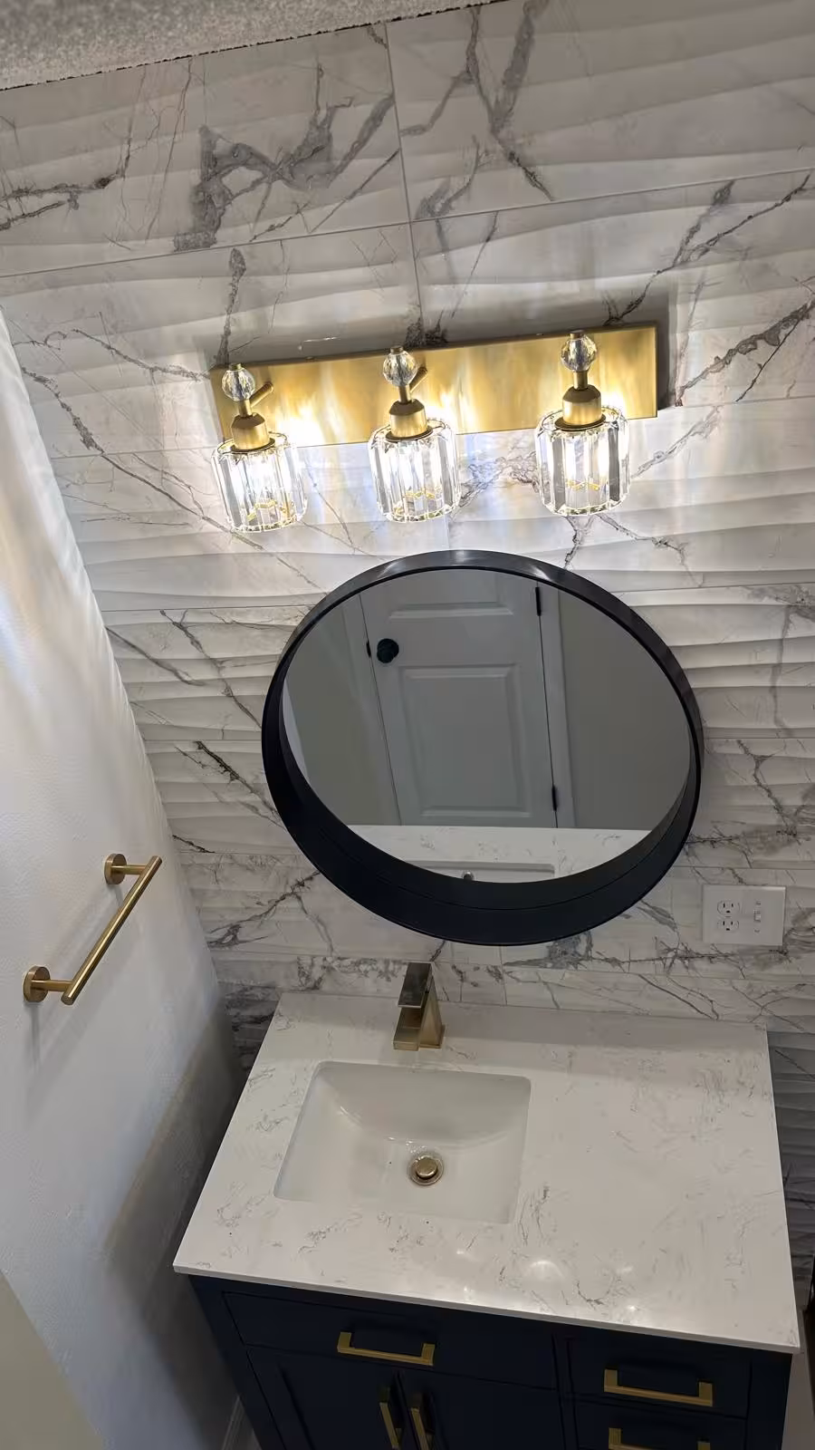 Round mirror vanity light and custom vanity detail in Aurora bathroom remodel
