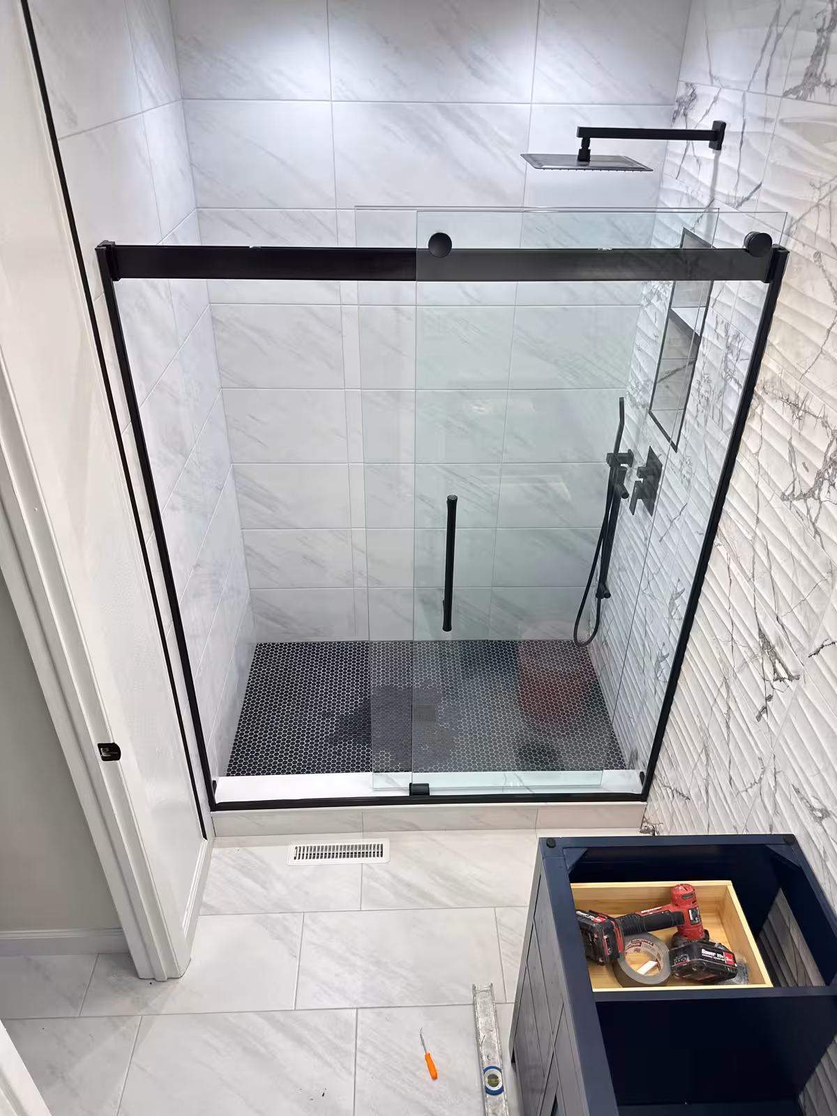 Finished walk-in shower with black glass door and dark mosaic floor in Aurora CO tub-to-shower conversion