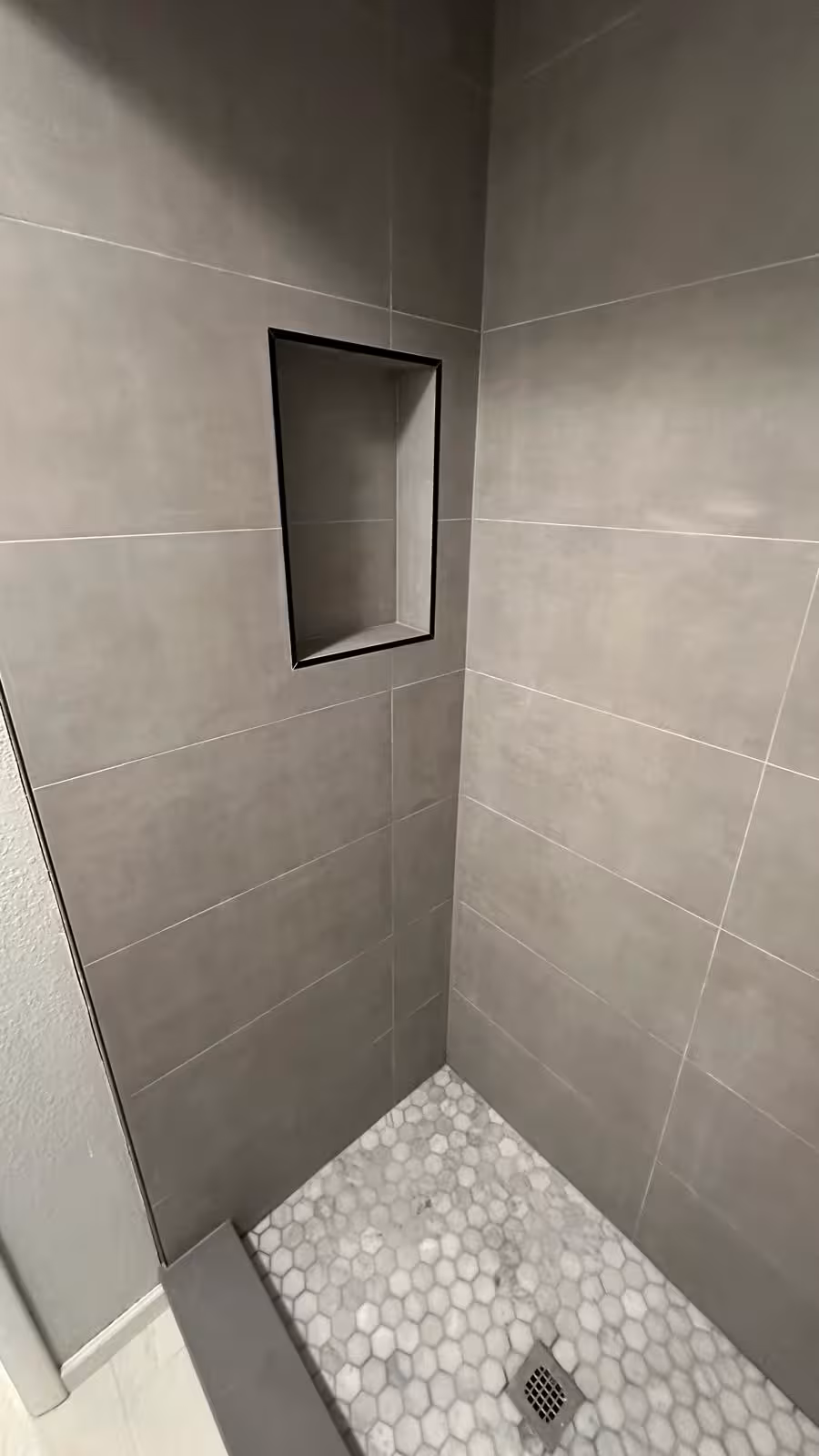 Recessed shower niche and mosaic floor in completed Arvada shower