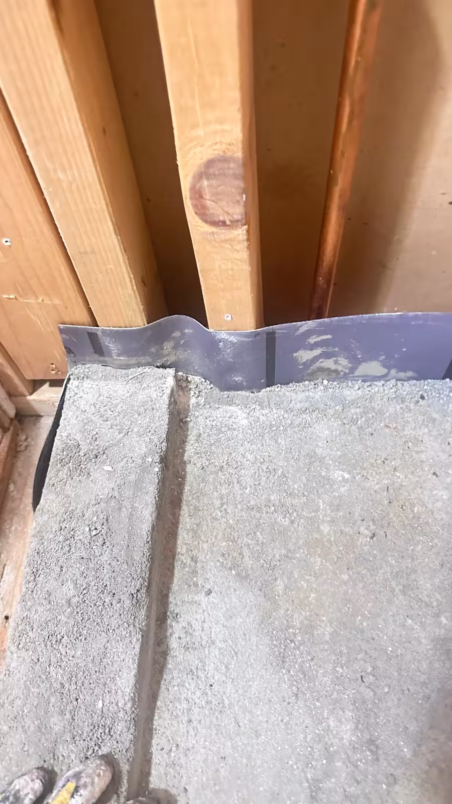 Damaged rubber shower liner between wall panels during Denver waterproofing inspection