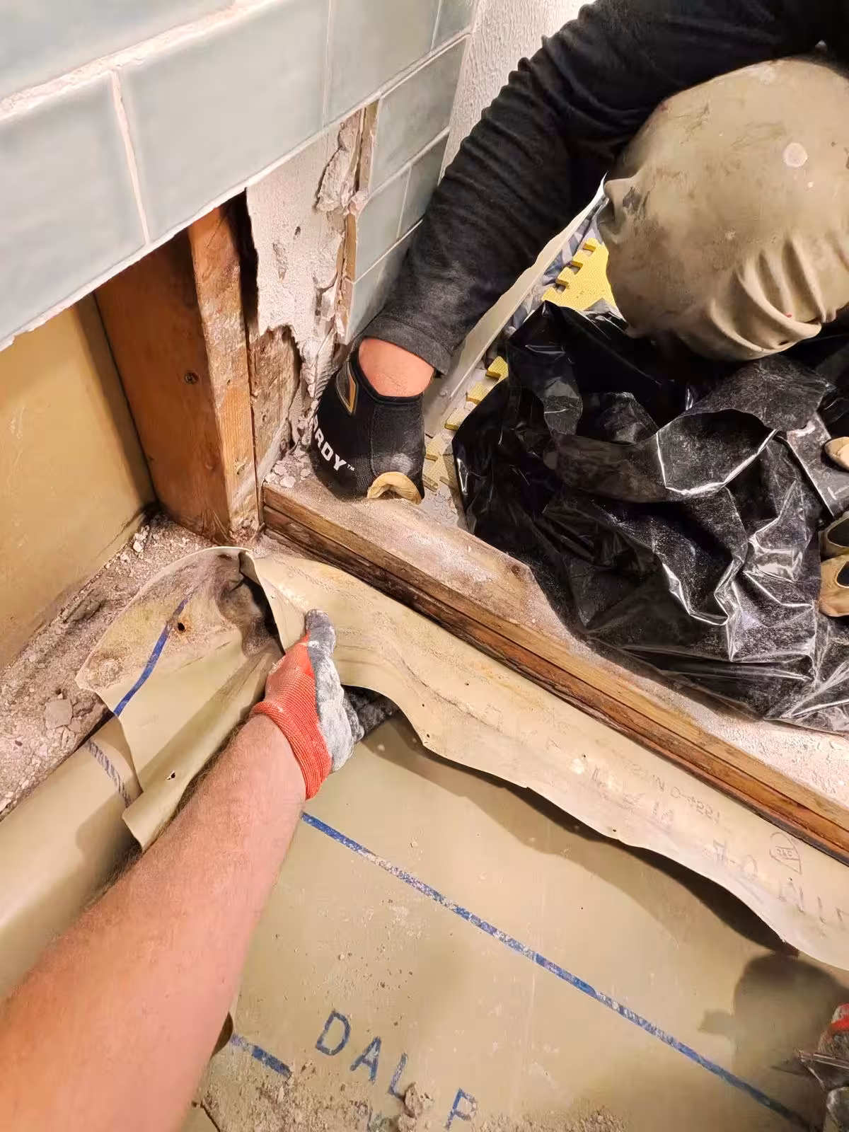 Shower pan framing repair showing wood studs and floor structure Denver