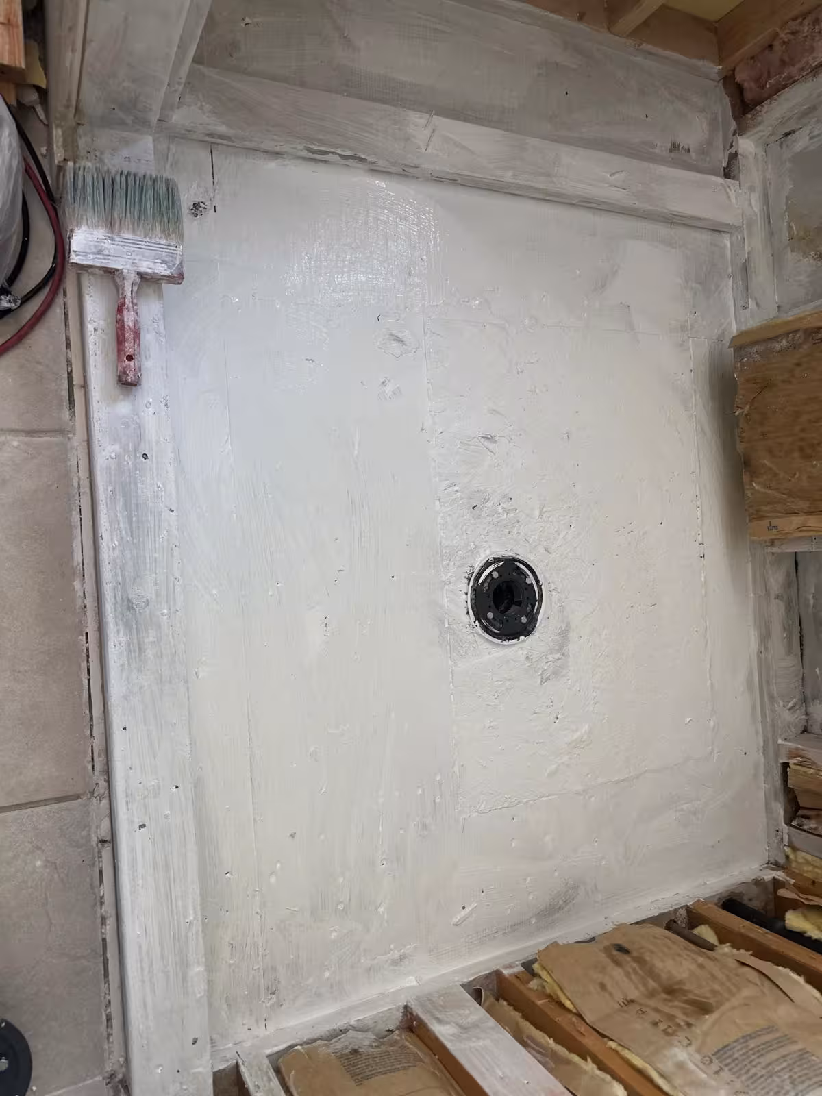 Primed and treated shower pan area after drying during DTC shower base repair