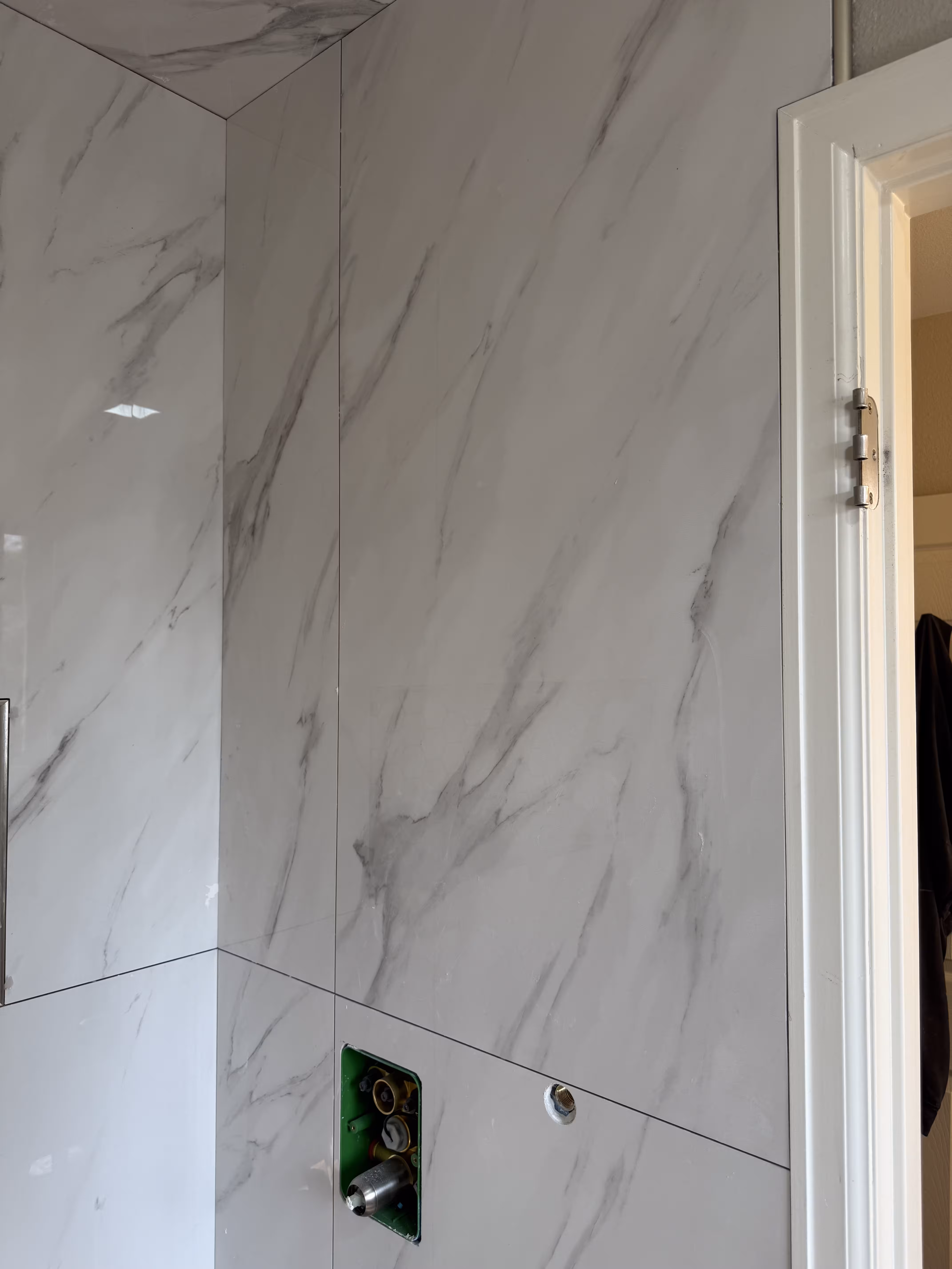 24x48 marble-look wall tile installation detail in luxury shower remodel Highlands Ranch