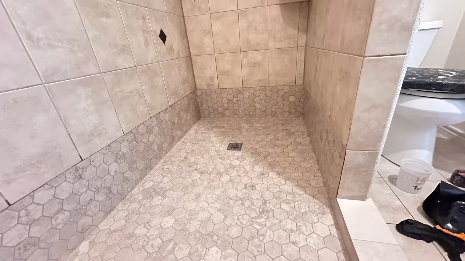 Wide angle view of completed shower remodel with hexagon floor tile Elizabeth Colorado