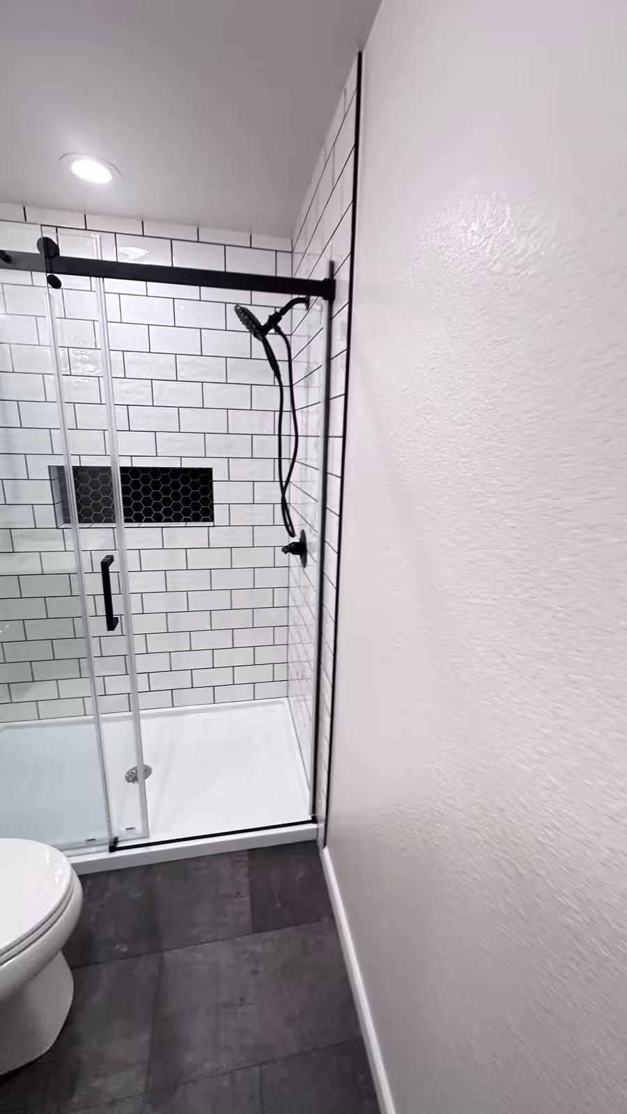 Modern white subway tile shower with black-framed glass enclosure