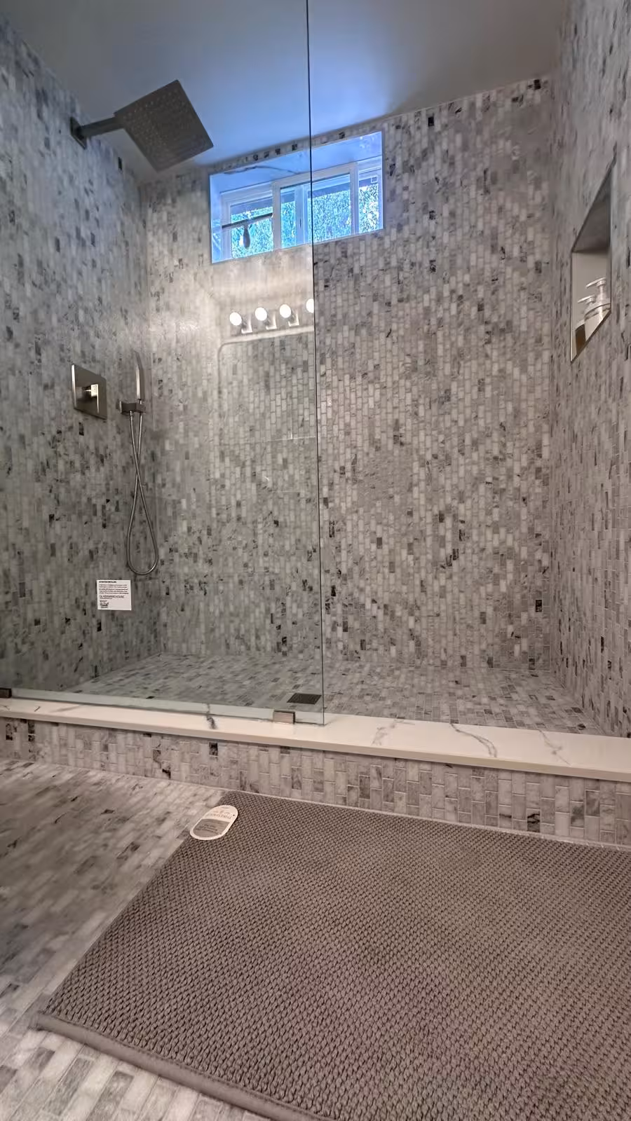 Custom walk-in shower with marble mosaic tile and rainfall head Littleton basement