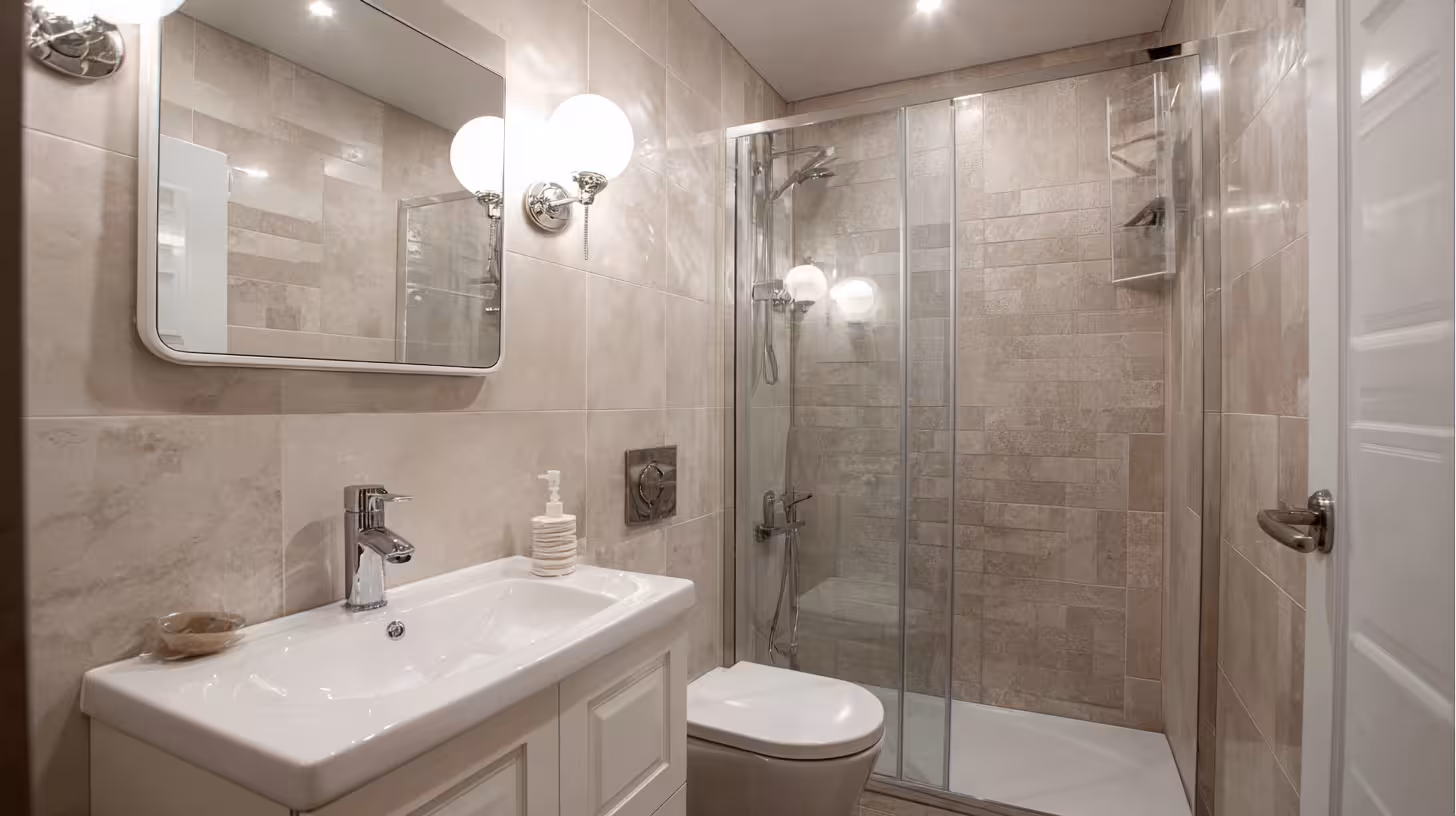 Compact bathroom using light-colored large format tiles to appear larger.