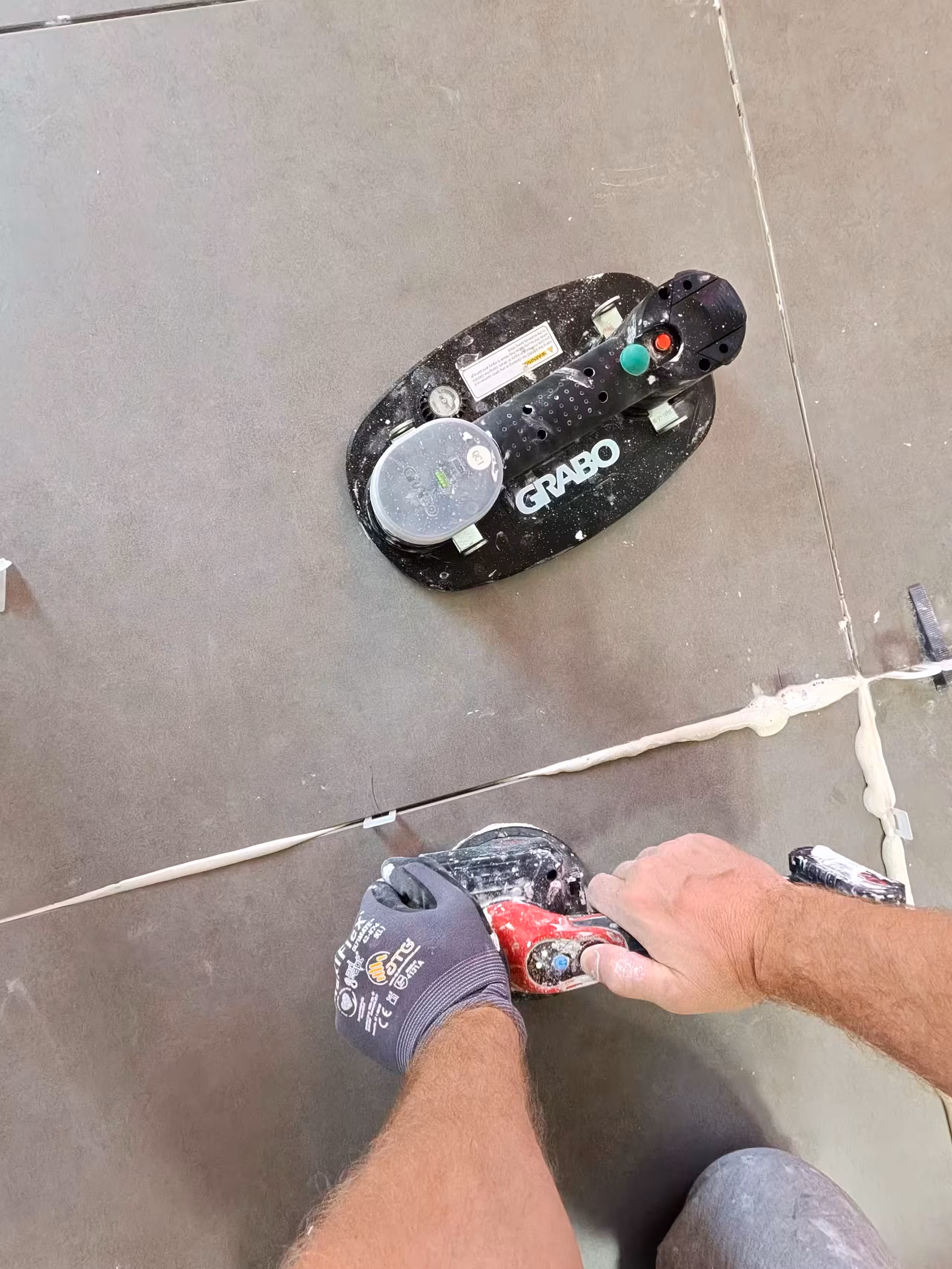 Professional tile installer checking alignment in Denver project