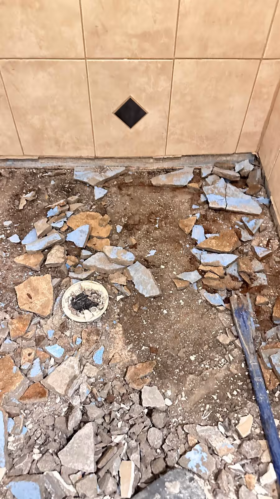 Tile removal in progress during shower floor demolition revealing extent of damage Elizabeth CO