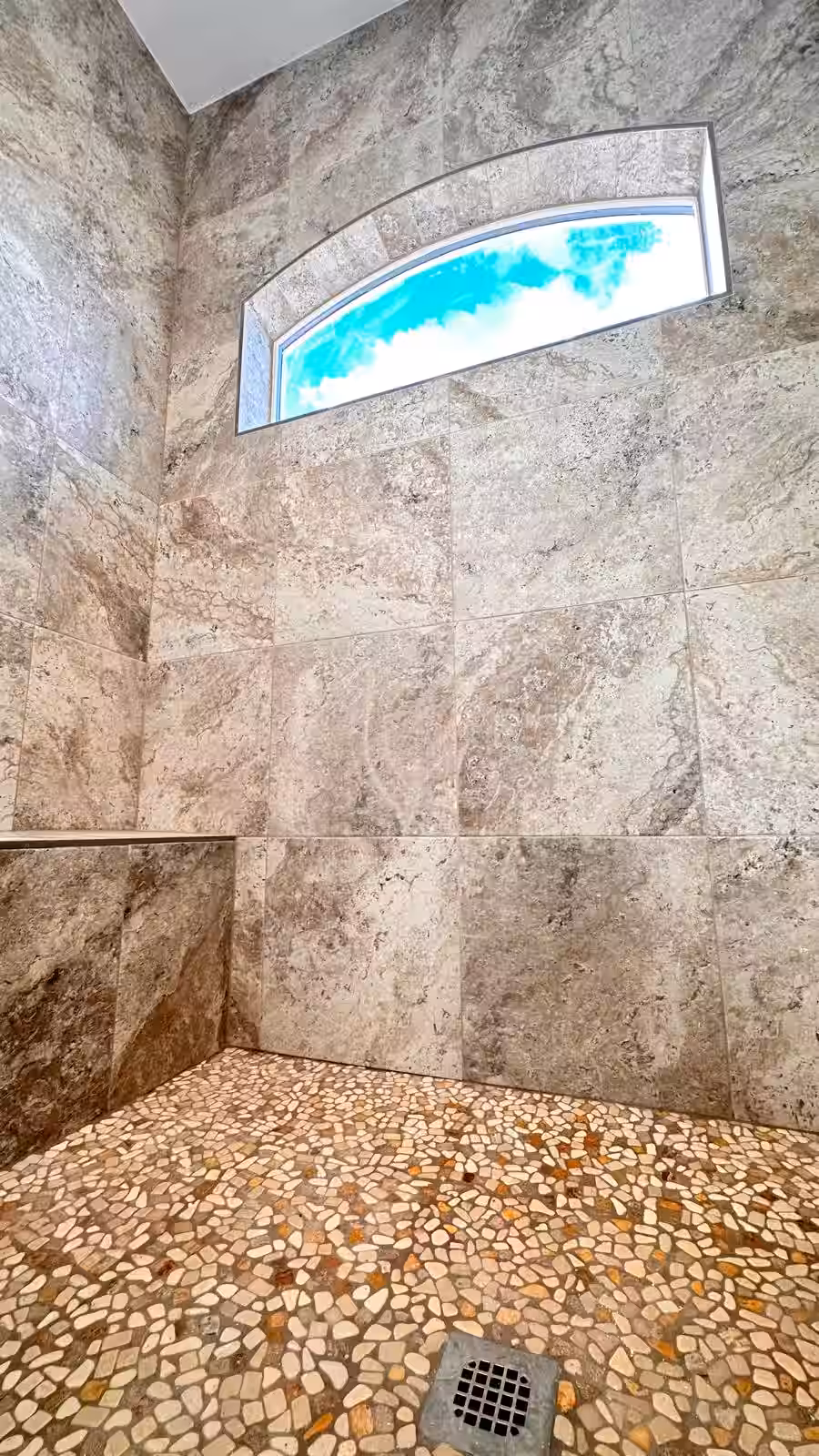 Completed shower remodel featuring natural stone tile and custom details