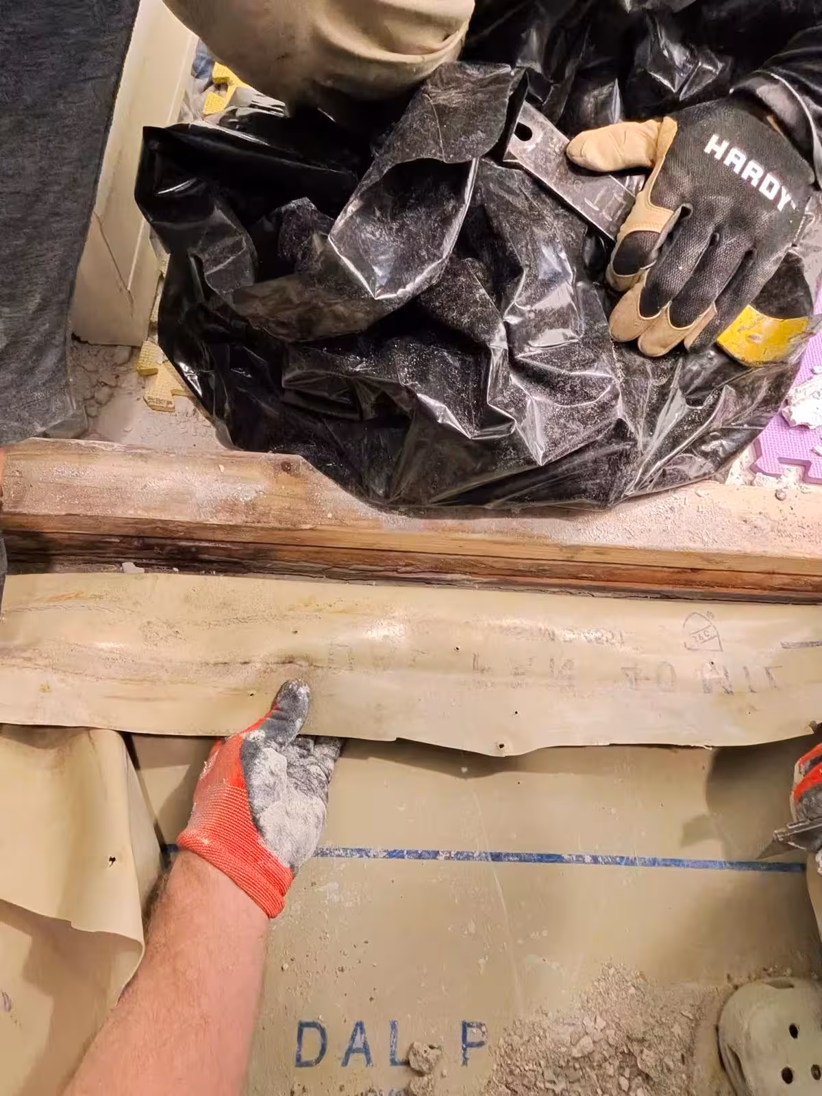 Old failed shower pan liner removal process showing damage Denver